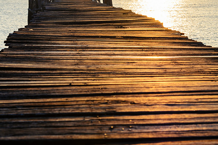 Sea at sunrise stock photo containing bridge and wood, a Nature Photo by yongkiet jitwattanatam