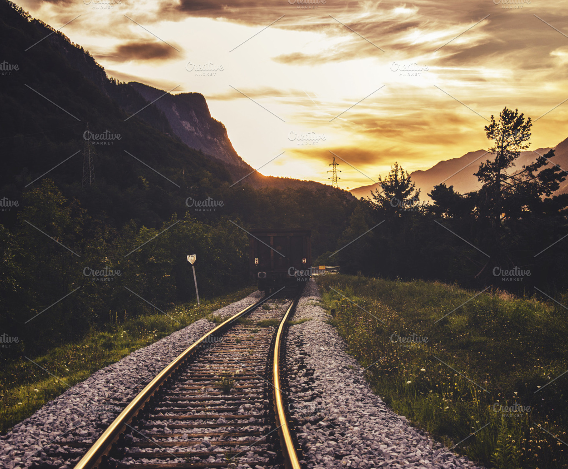 Train traveling in the sunset stock photo containing railway and tracks