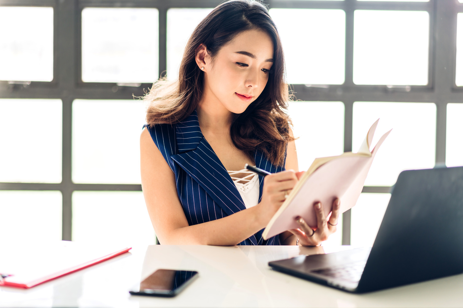 Portrait of woman using technology of laptop computer while sitt, a ...
